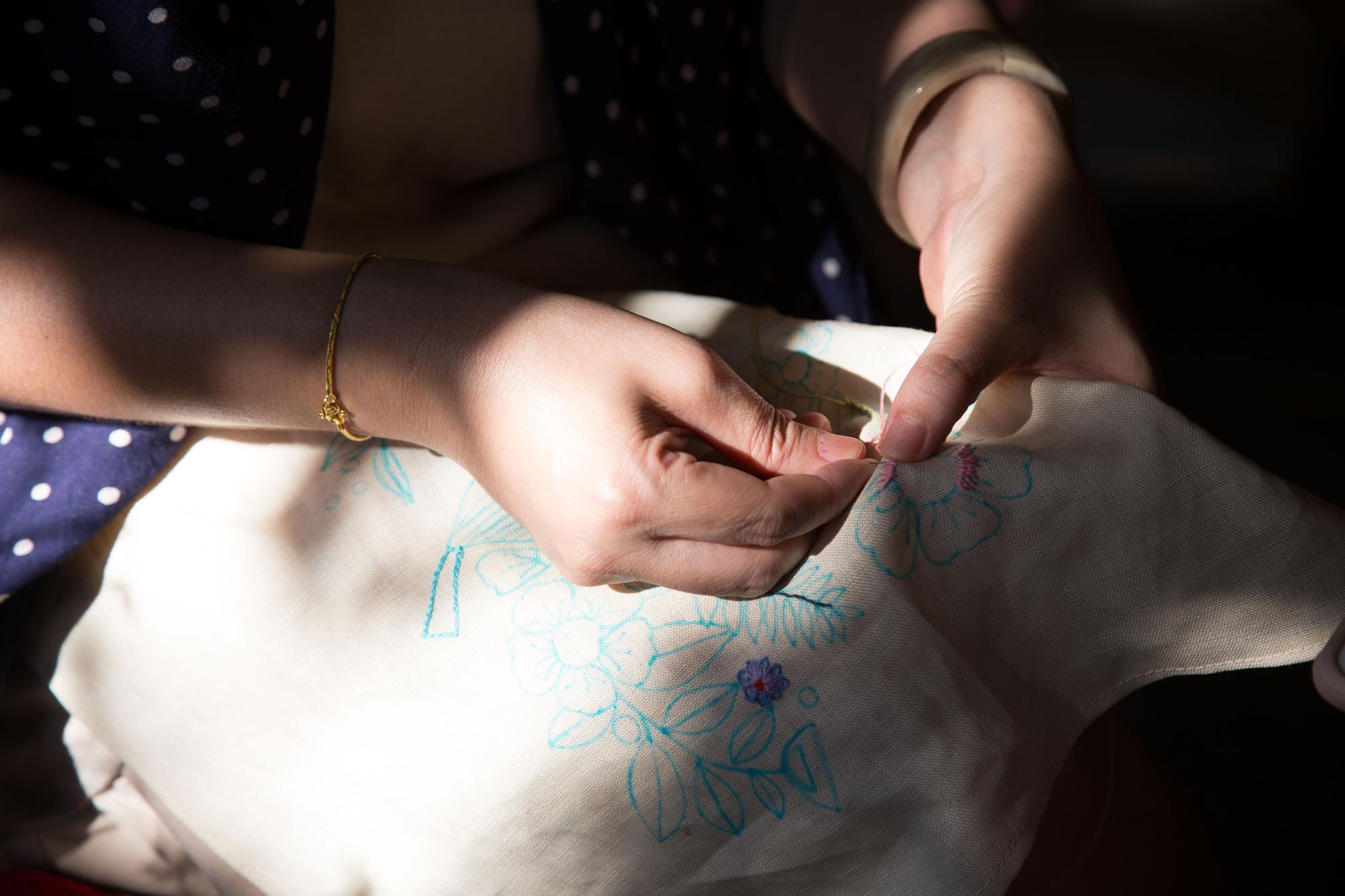 Studio hands stitching delicate pattern